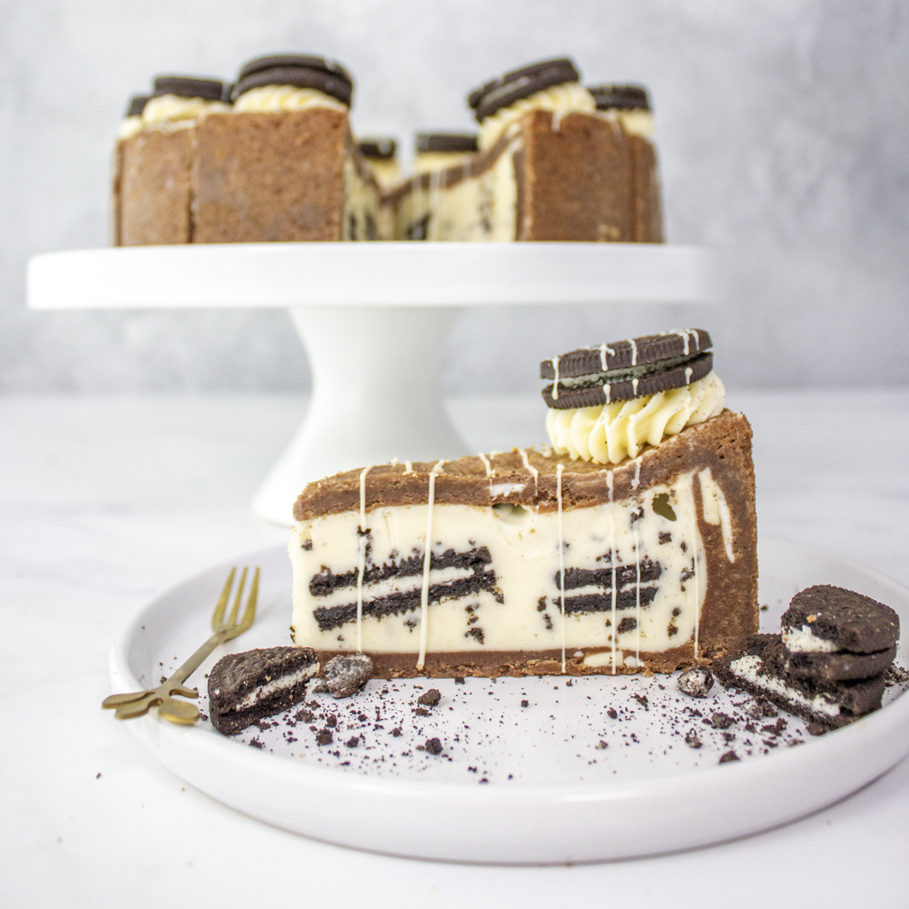 DoughGirl Full Cookies ’n Cream Cookie Pie on cake stand with slice and Oreo filling