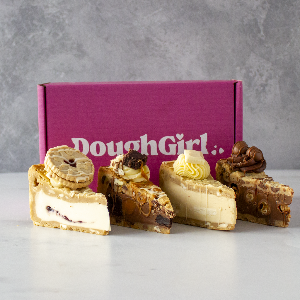 Four cookie pie slices in front of a DoughGirl box on a grey background