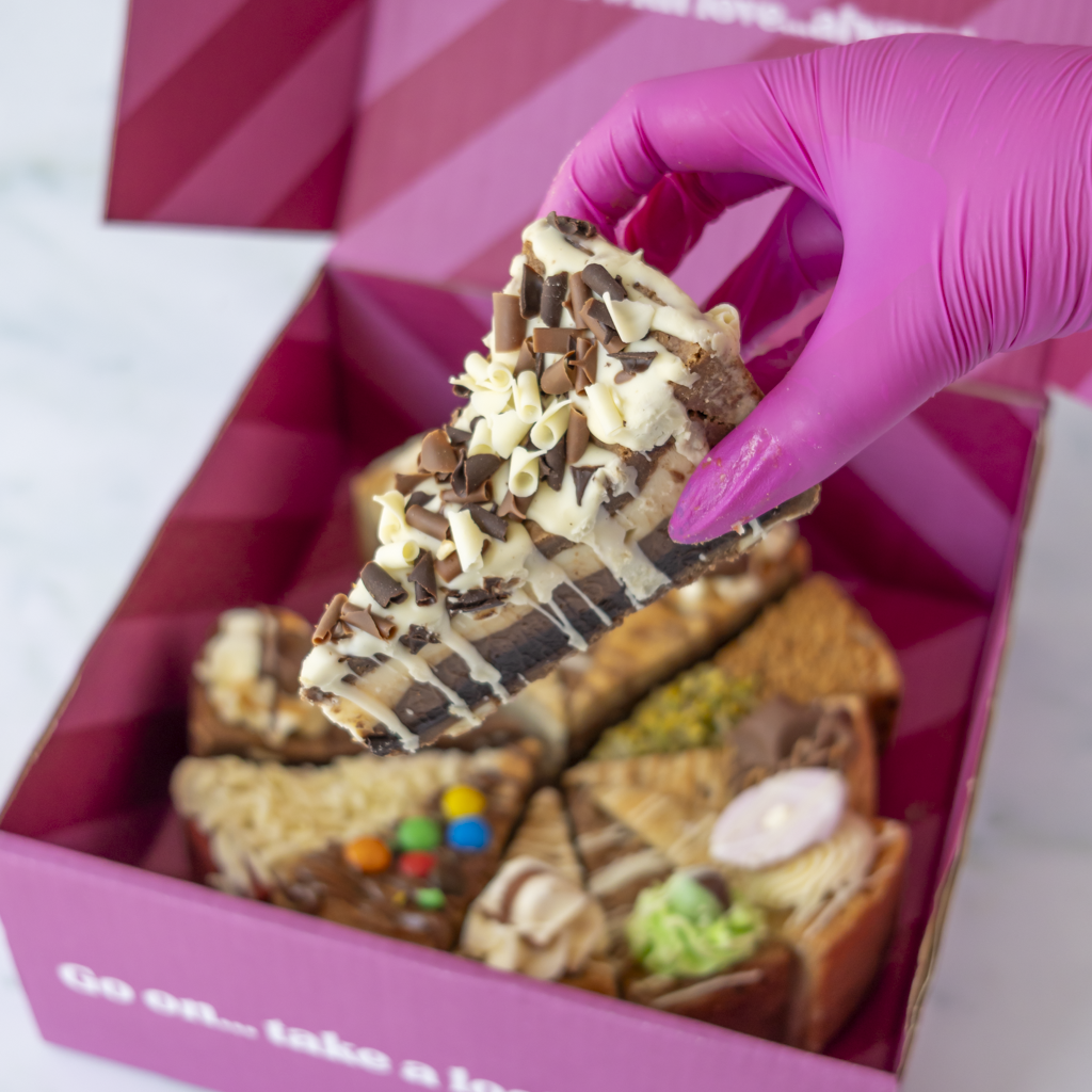 DoughGirl cookie pie box featuring triple chocolate cookie pie slice and other slices in a pink branded box