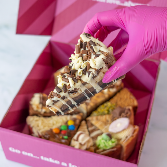 DoughGirl cookie pie box featuring triple chocolate cookie pie slice and other slices in a pink branded box