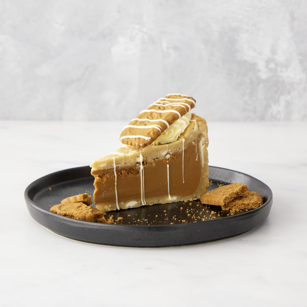 Cookie pie slice topped with biscuit pieces and white chocolate drizzle