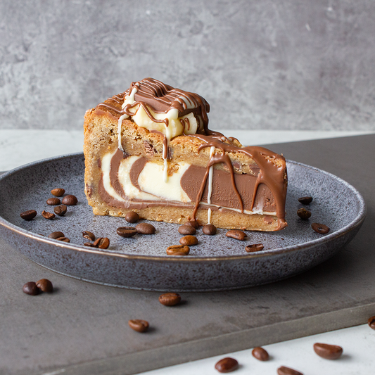DoughGirl cookie pie slice with chocolate drizzle, creamy filling and coffee beans on a plate