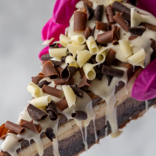 Chocolate cookie pie slice topped with milk and white chocolate curls