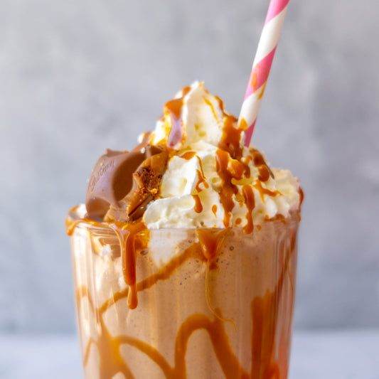 Close-up of a caramel cookie pie milkshake topped with whipped cream and sauce