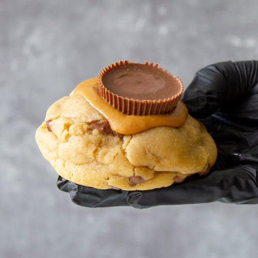 DoughGirl chunky cookie topped with peanut butter cup held by hand