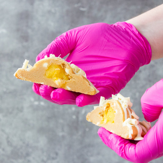 DoughGirl cookie pie broken open by hand showing gooey filled centre and crumbly cookie texture