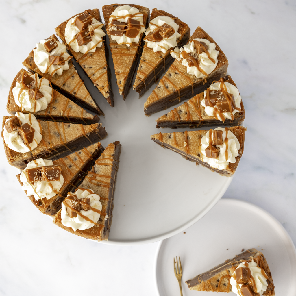 12 cookie pie slices arranged on a plate with caramel drizzle