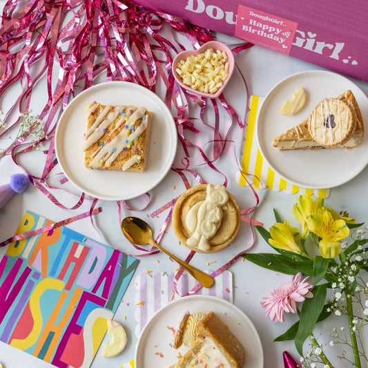 DoughGirl birthday cookies and cookie pie slices arranged with party decorations and flowers