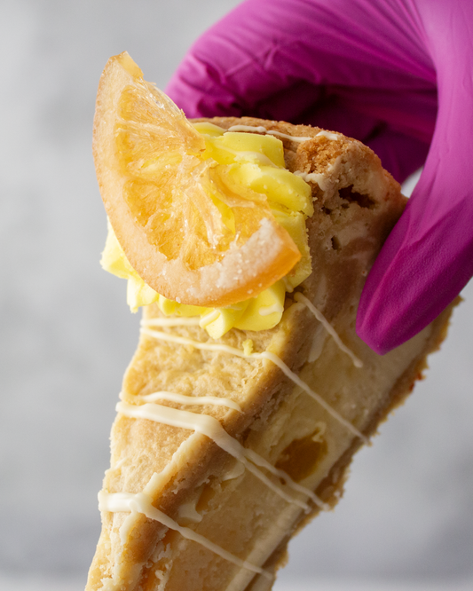 DoughGirl lemon cookie pie slice with white chocolate drizzle held by hand