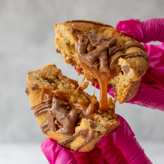 Gooey caramel-filled cookie pulled apart by hand