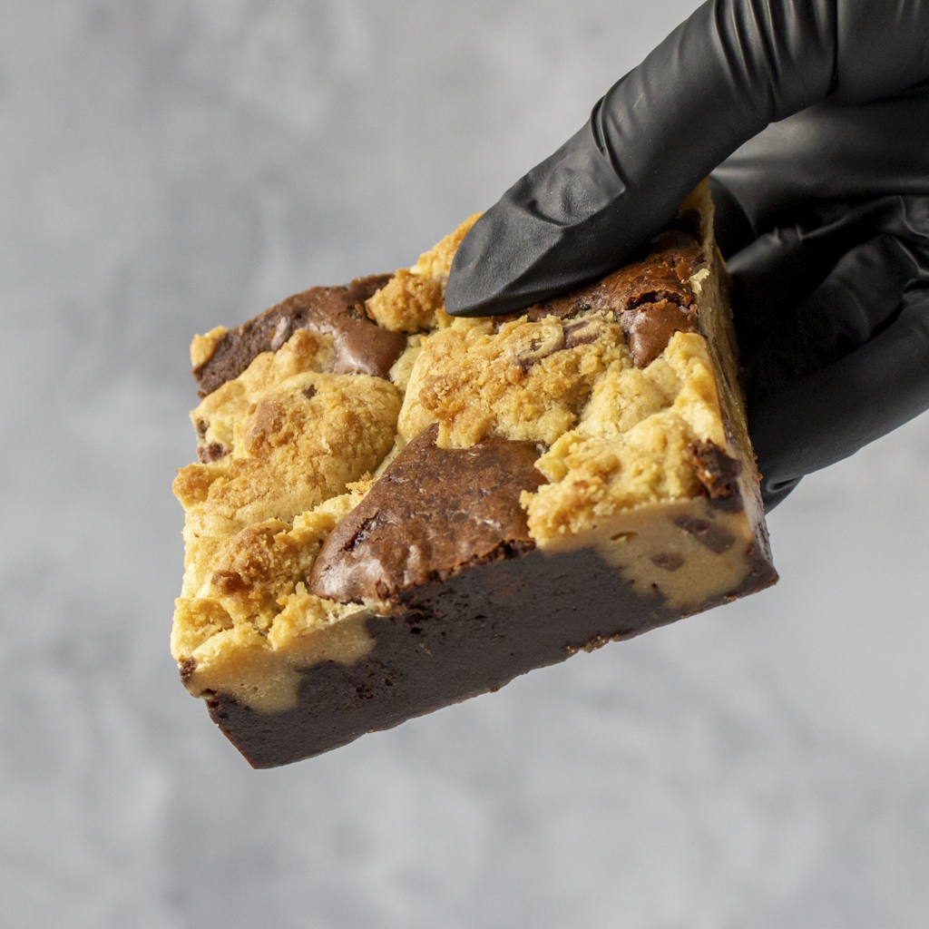 Hand wearing a black glove holding a Classic Brookie Slab against a gray background