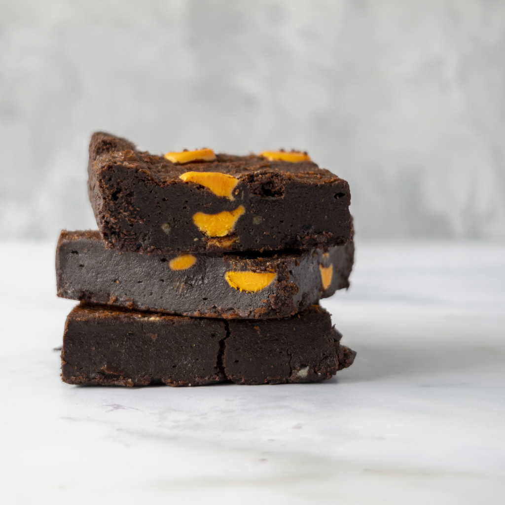 Stack of Chocolate Orange Brownie Slab with orange specks on a marble surface