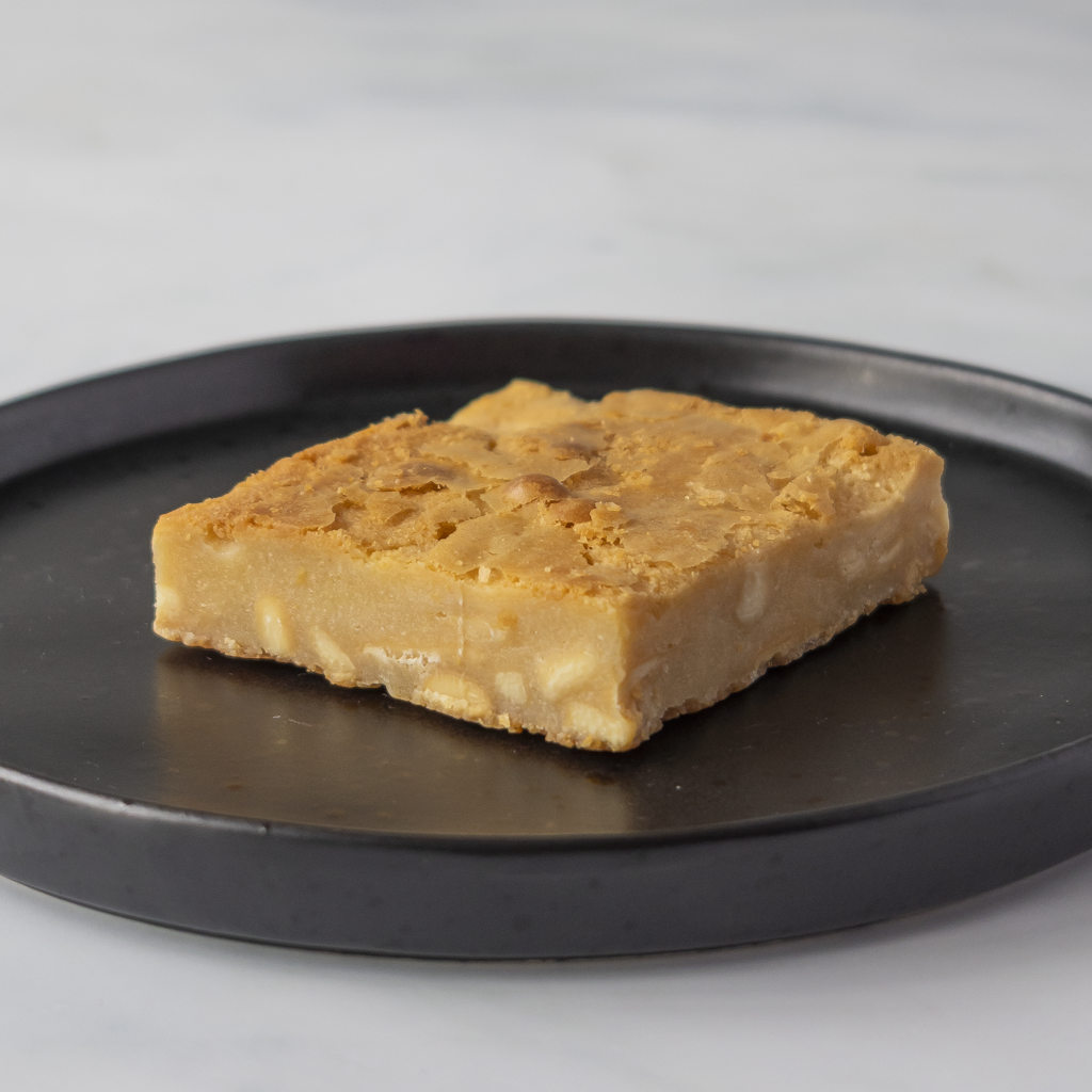 Classic Blondie Slab served on black plate showing thick blondie base