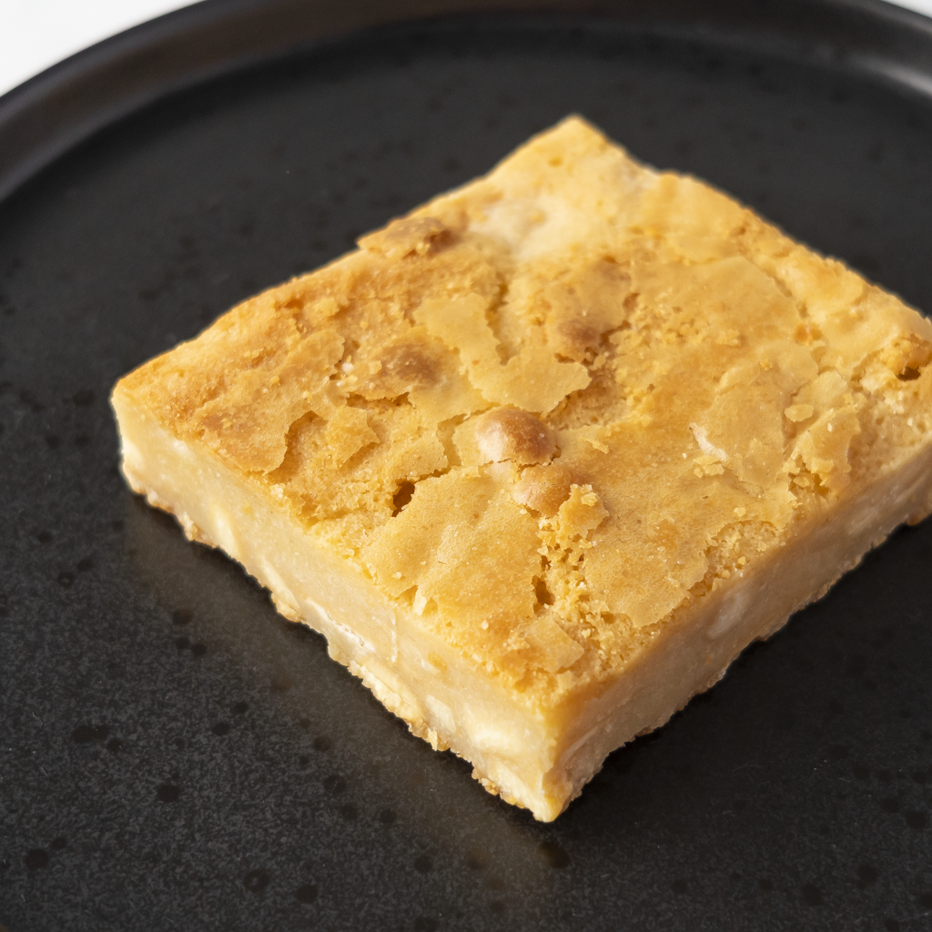 DoughGirl Classic Blondie Slab served on black plate with gooey vanilla blondie texture