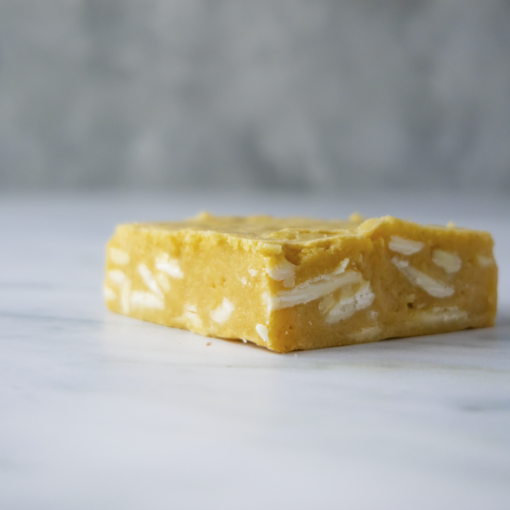 close-up of layered Classic Brookie Slab on a marble surface with a gray background