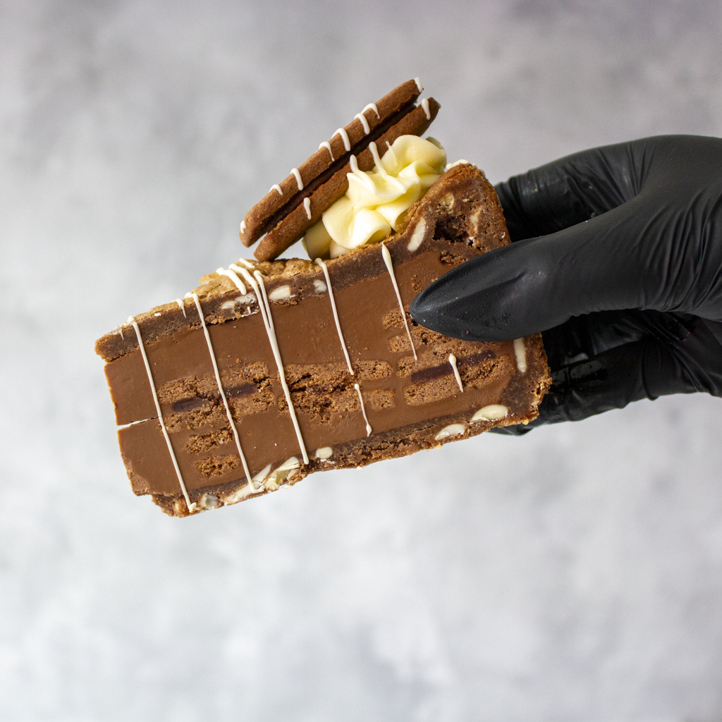 Bourbon Biscuit Cookie Pie Slice held in black glove showing chocolate cookie pie layers
