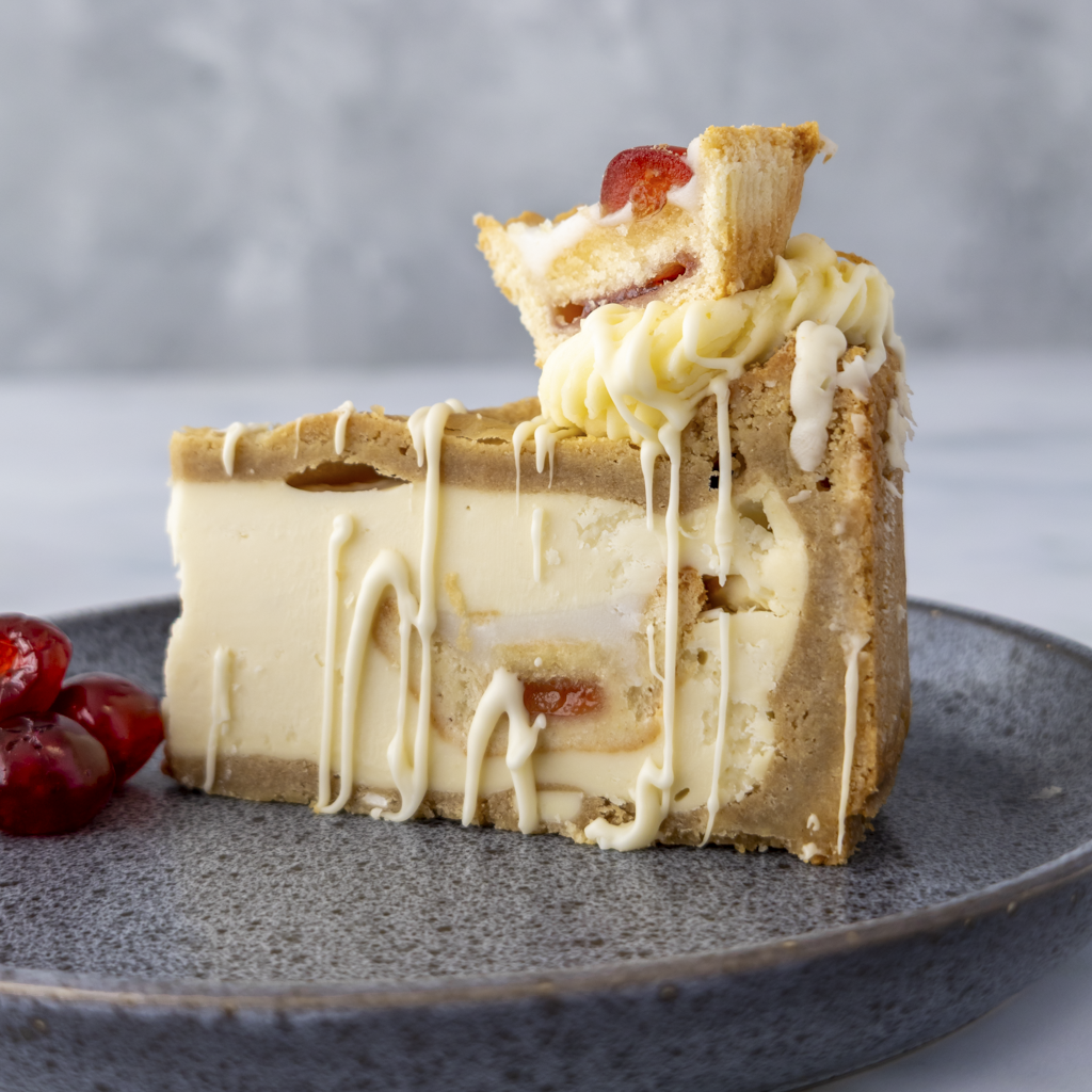 Slice of layered cake with white frosting on a gray plate
