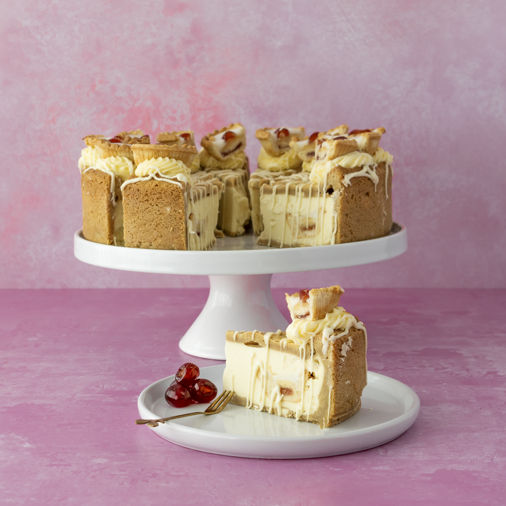 DoughGirl 12-Slice Cherry Bakewell Cookie Pie on a white stand with a pink background