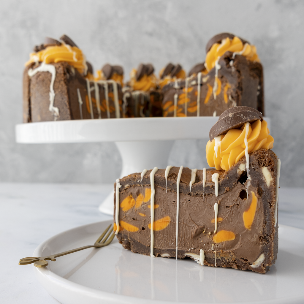 Chocolate cookie pie slice with orange and white drizzle on a white plate with a blurred background