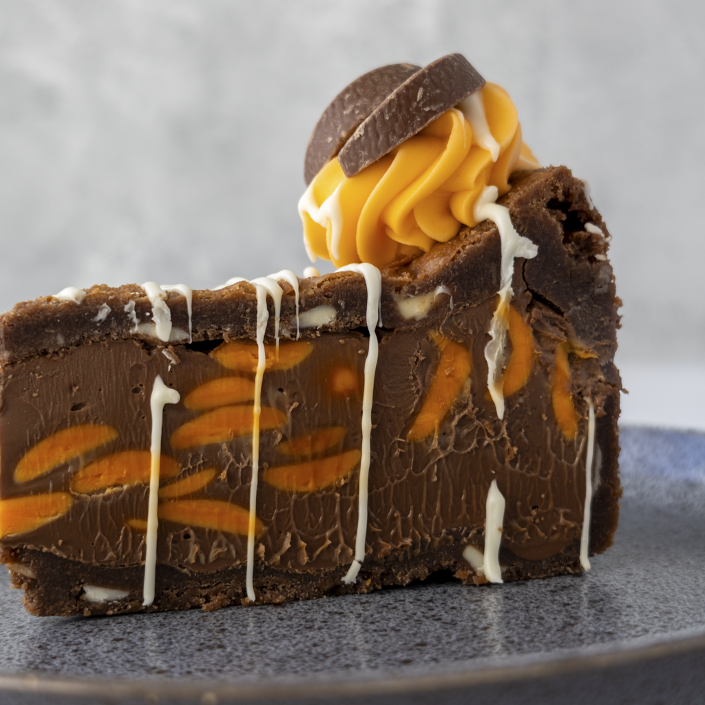 Chocolate Orange Cookie Pie Slice served on black plate with orange white chocolate drizzle