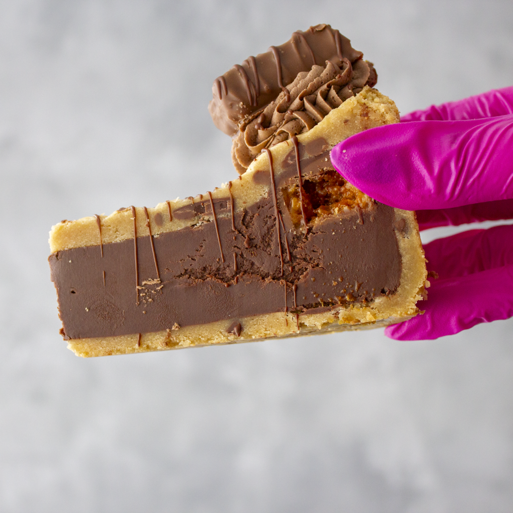 DoughGirl Cookie Pie Slice with Crunchie held in pink glove with honeycomb and chocolate filling