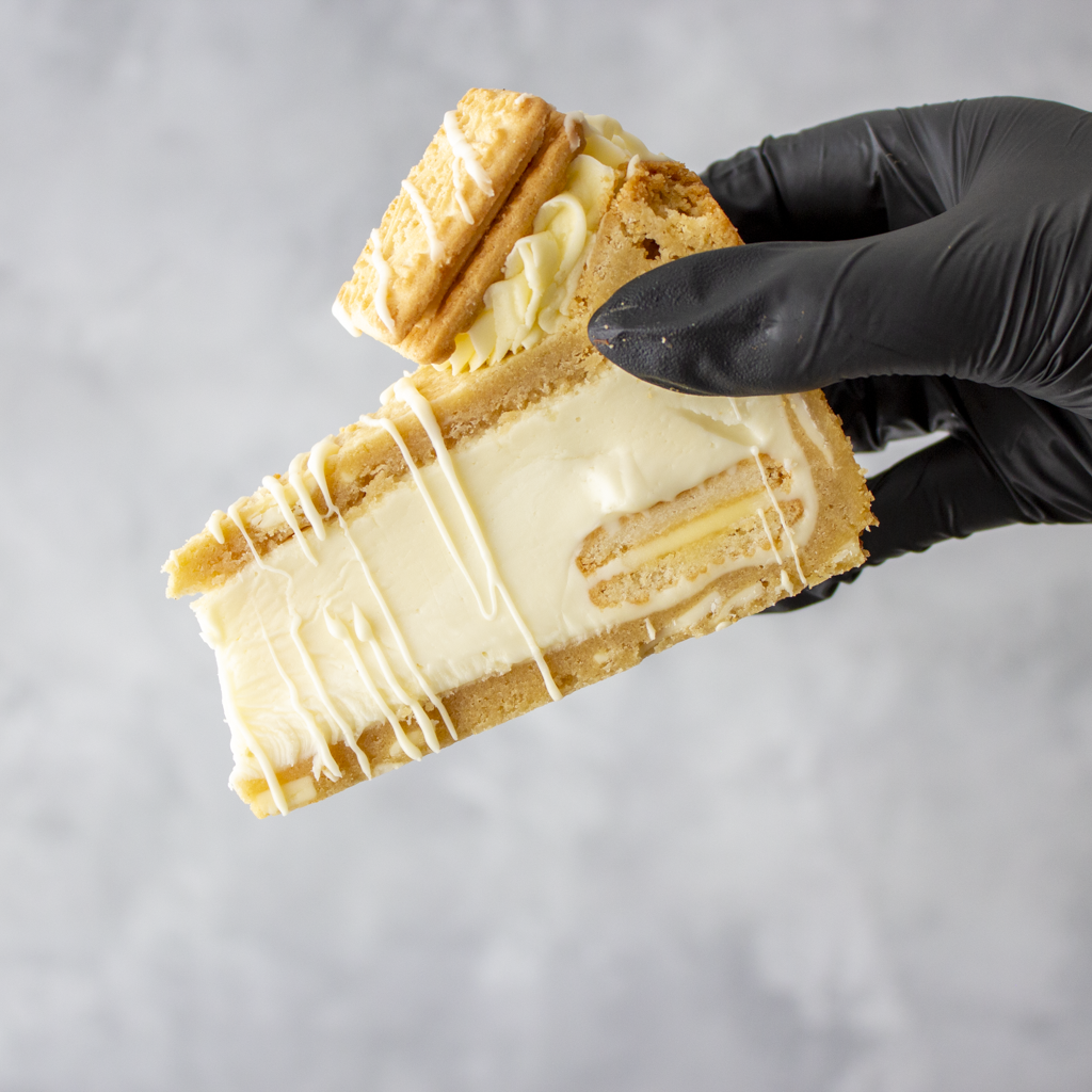 Custard Cream Cookie Pie Slice held in black glove showing creamy white chocolate filling