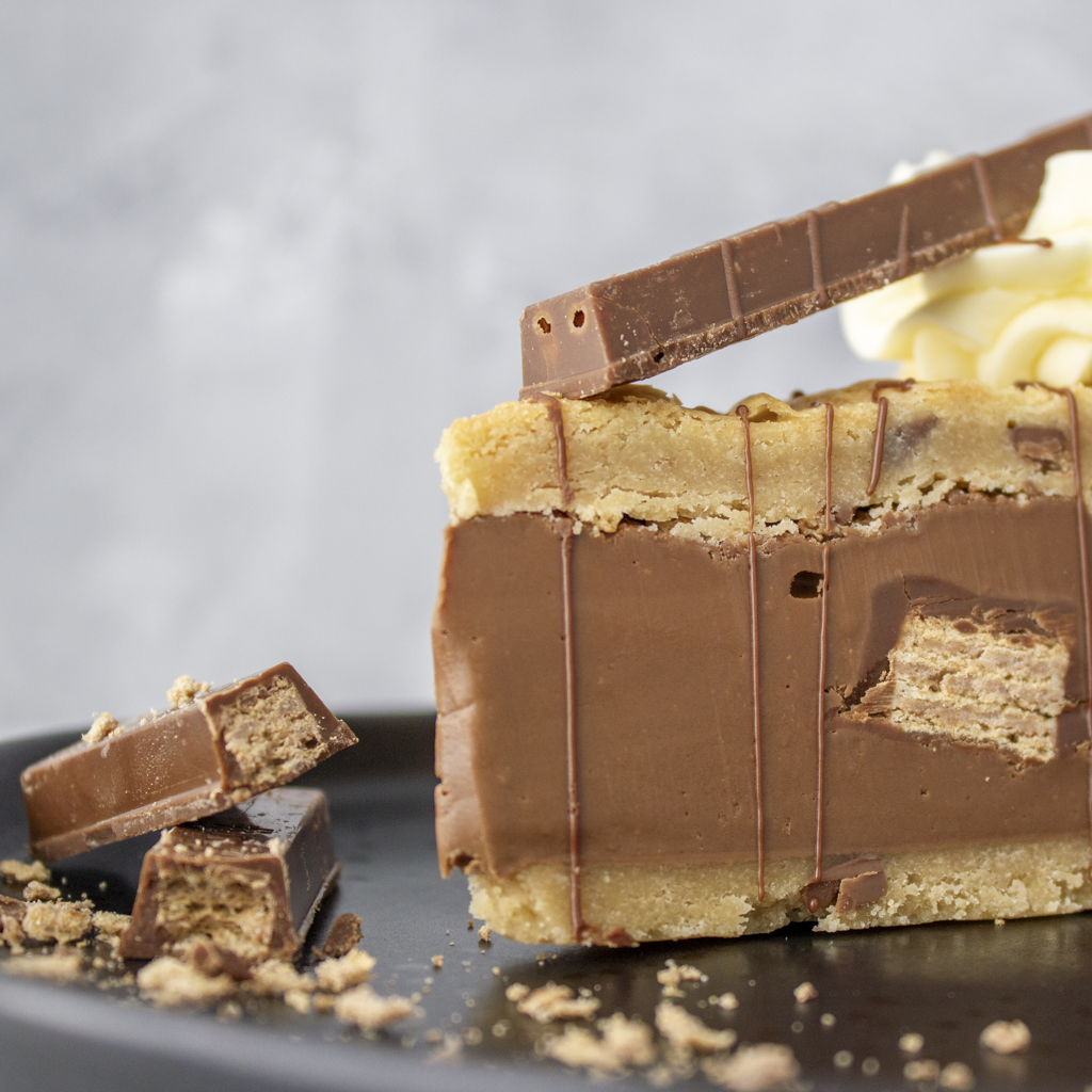 Close-up of a KitKat Crunch Cookie Pie with KitKat chocolate bars on a gray background