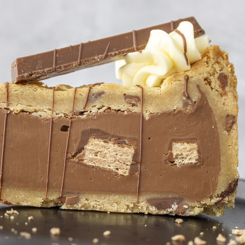Close-up of a KitKat Crunch Cookie Pie Slice with chocolate and cookie pieces on a gray background
