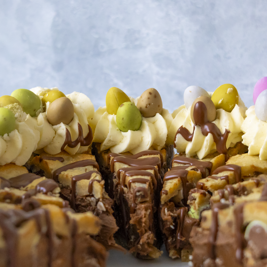 Close-up of a Easter dessert with chocolate and Mini Eggs decorations on a light blue background
