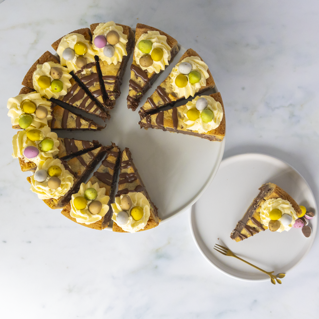 Decorative cake for Easter treat with a slice removed, showing a marble countertop background.