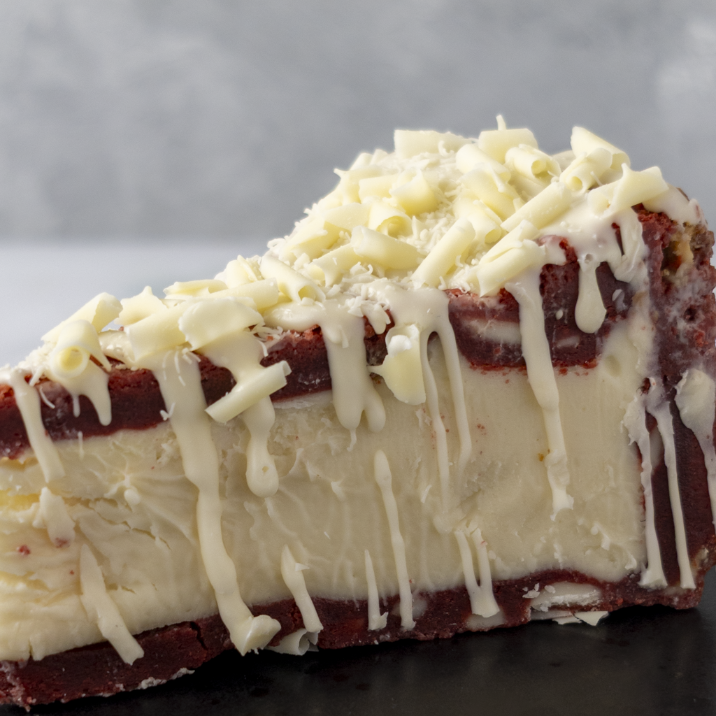 Side view of DoughGirl Red Velvet Cookie Pie Slice with creamy white chocolate filling