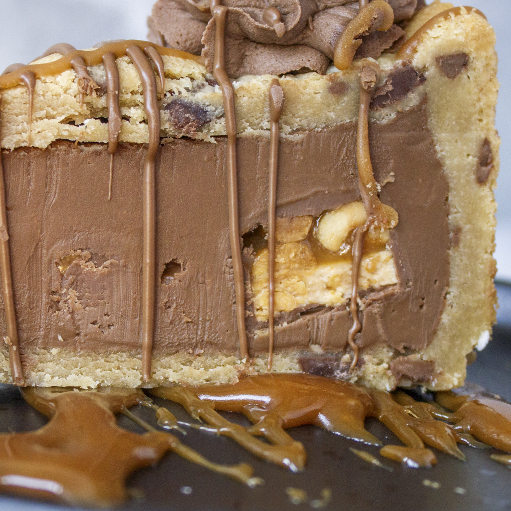 Close-up of Cookie Pie Slice with Snickers showing peanuts, caramel and chocolate filling