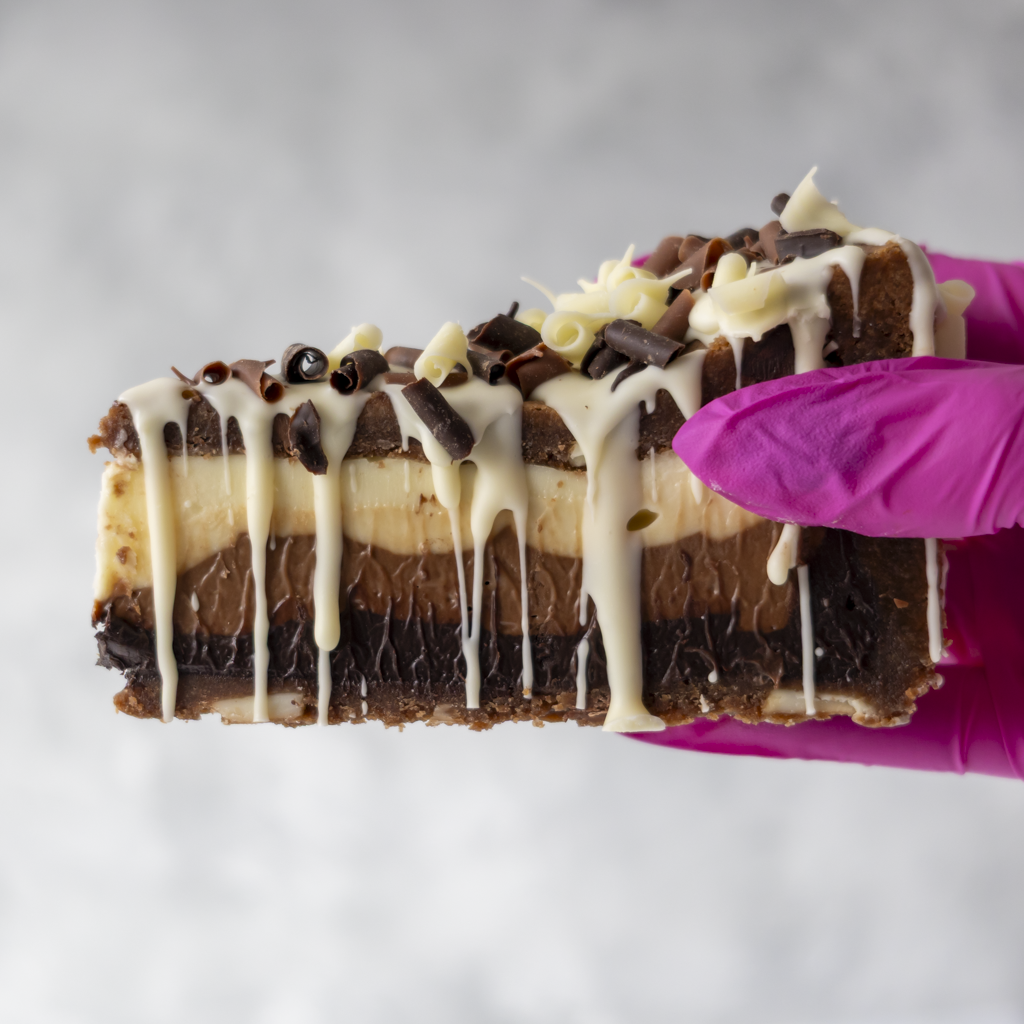 Triple Chocolate Cookie Pie Slice held in pink glove showing thick chocolate layers