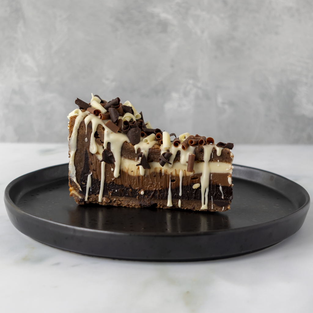 DoughGirl Triple Chocolate Cookie Pie Slice served on black plate with chocolate drizzle