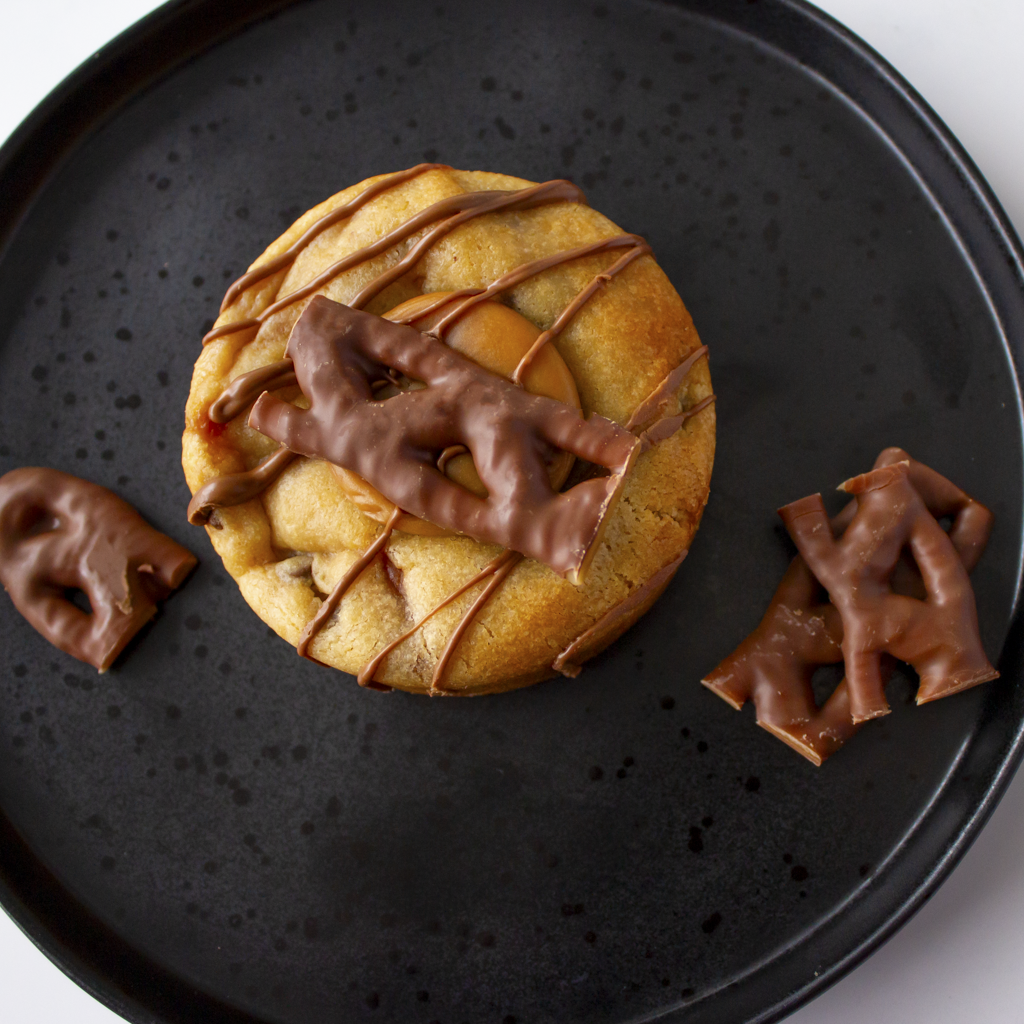 Overhead view of DoughGirl Curly Wurly Deluxe Cookie with chocolate bar pieces