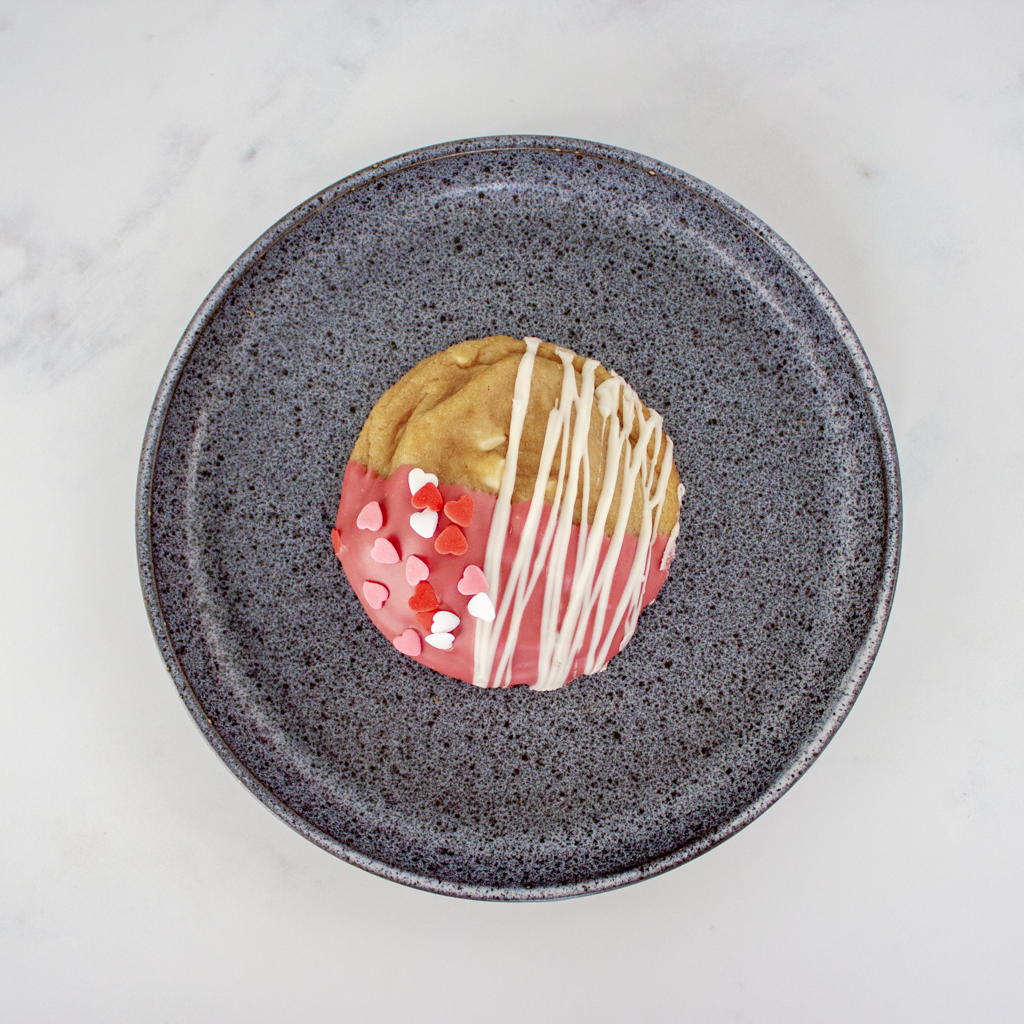 Colorful cookie on a speckled gray plate against a light background, perfect for Valentine dessert