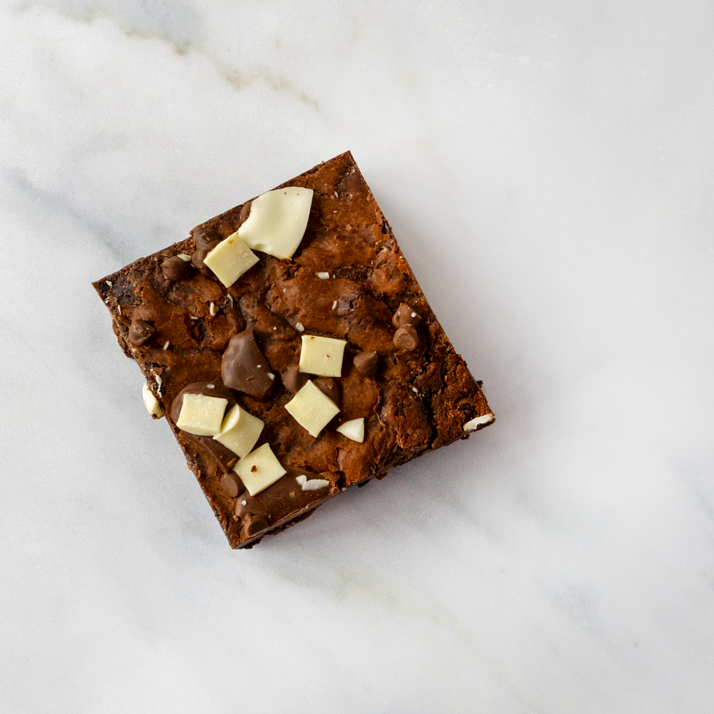 Brownie sweet treat with white chocolate chips on a marble surface