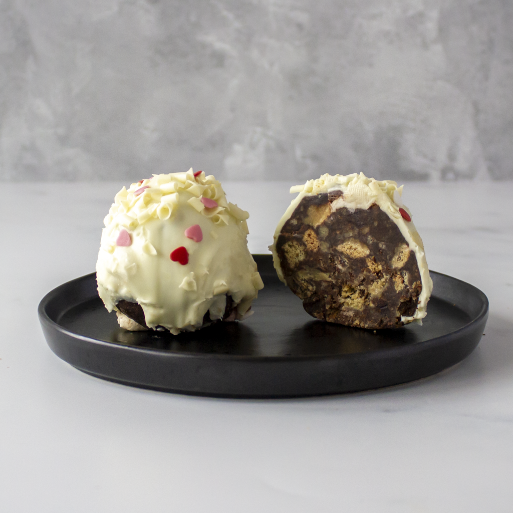 Two Filthy Fluff Brookie Choccy Boom Bites on a black plate with a gray background, perfect gift for Valentine day or for sending cookies to your lovers