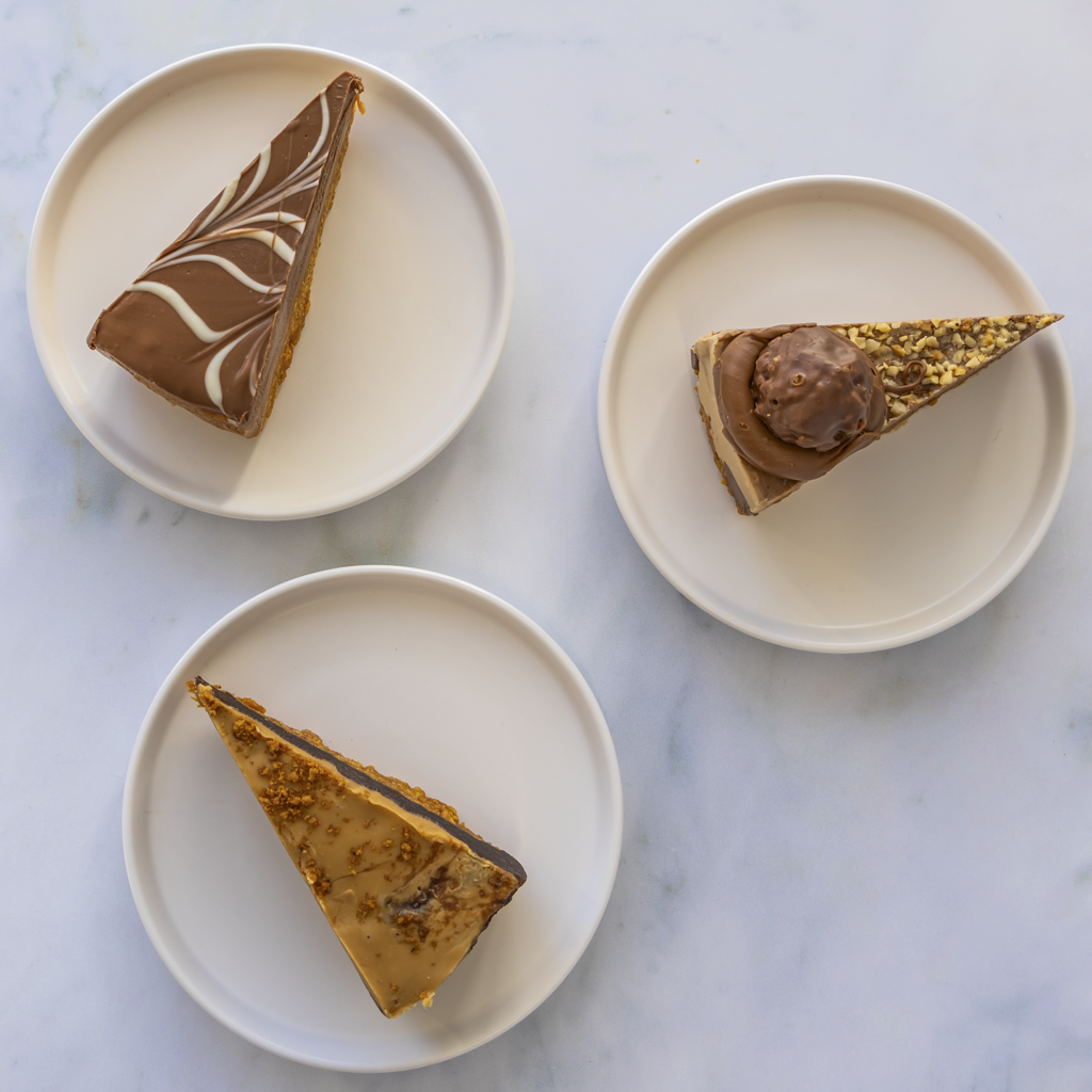 Three slices of chocolate cookie pie on white plates against a marble background