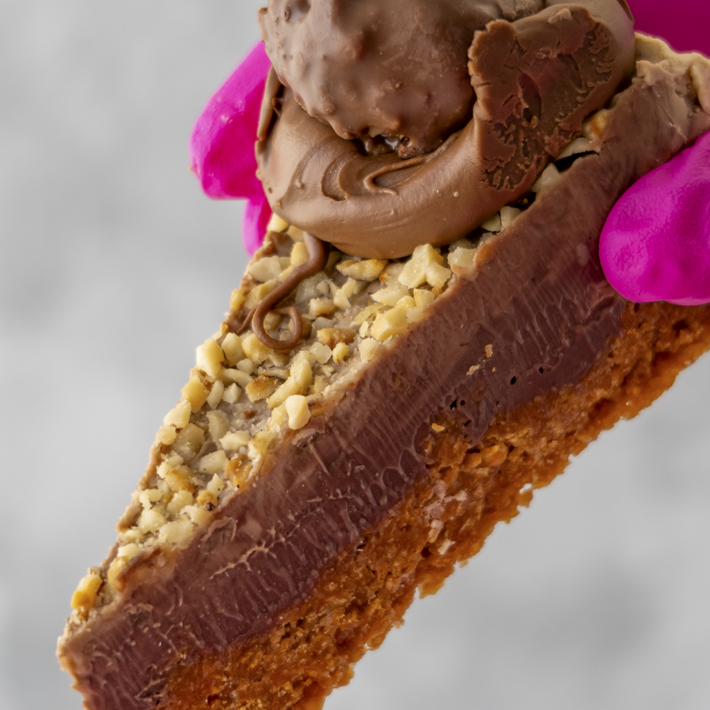 Close-up of a Hazelnut Cornflake Pie Slice with a cornflake base and creamy topping on a gray background