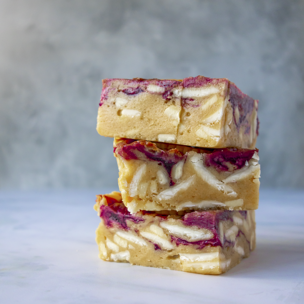 Stack of Jammie Dodger Blondie Slab, soft blondie, fruity jam and biscuit crunch, ideal for dessert, party, and cookie gift box.