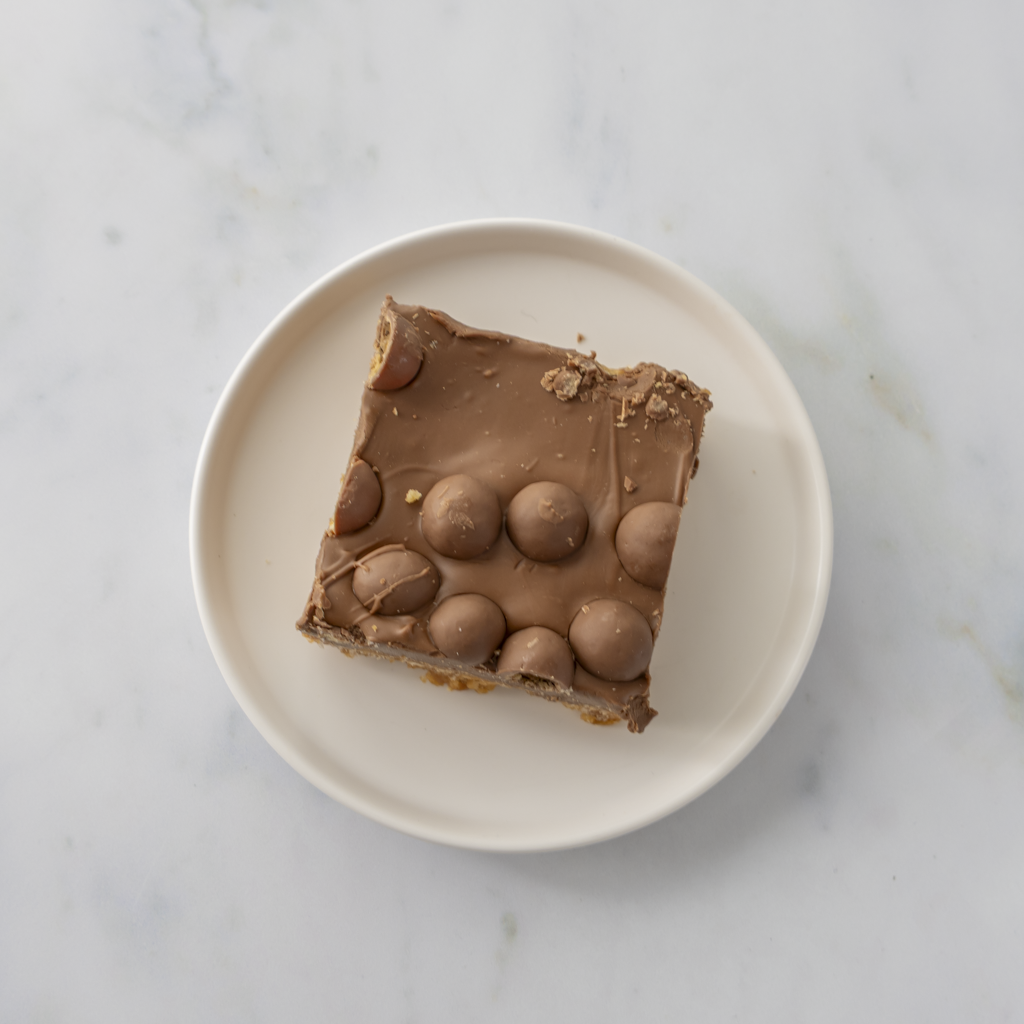 Chocolate Malteser crispie slab portion plated ready to serve