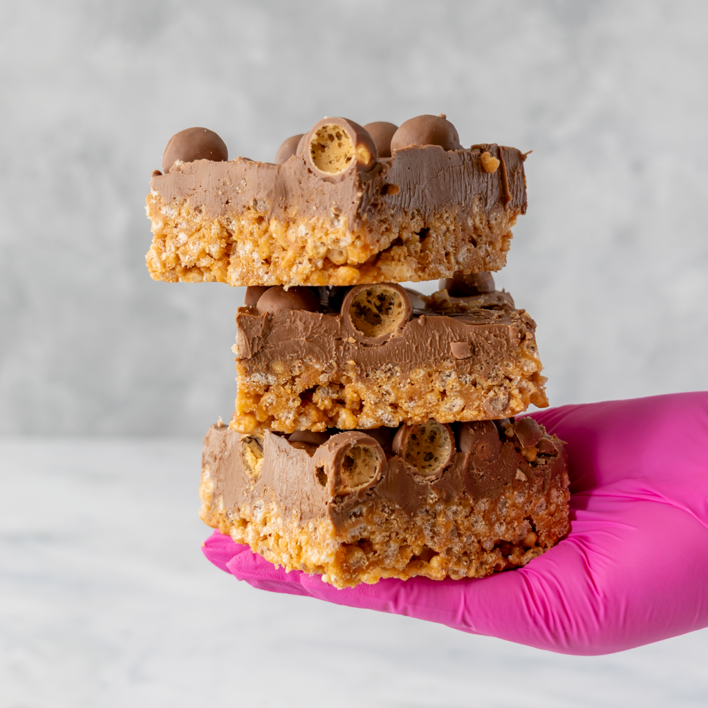 Malteser crispie slab dessert square showing caramel coated rice crispies and milk chocolate layer
