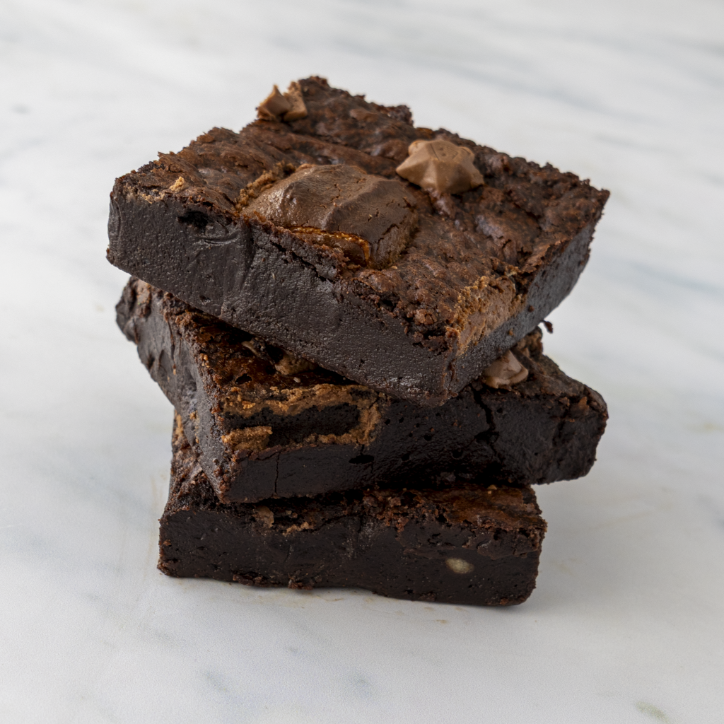 Stack of 3 chocolate brownies on a marble surface