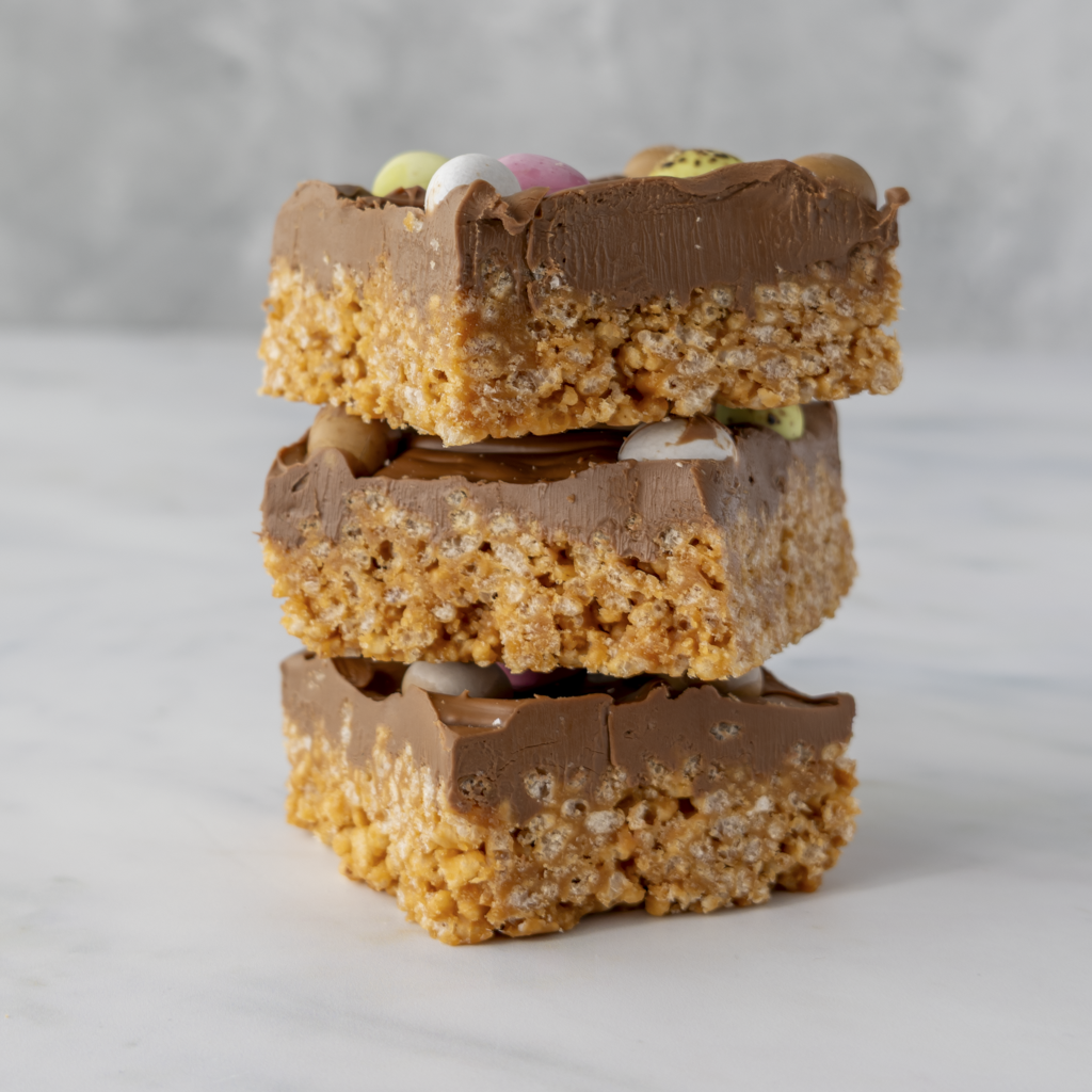 Close up of Mini Egg crispie slab layers with creamy milk chocolate and crunchy mini eggs