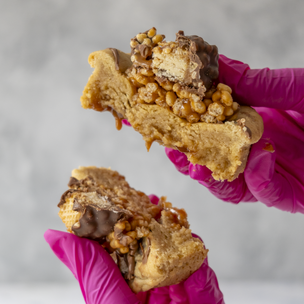DoughGirl Stuffed Deluxe Cookie with Lion Bar broken open with caramel filling