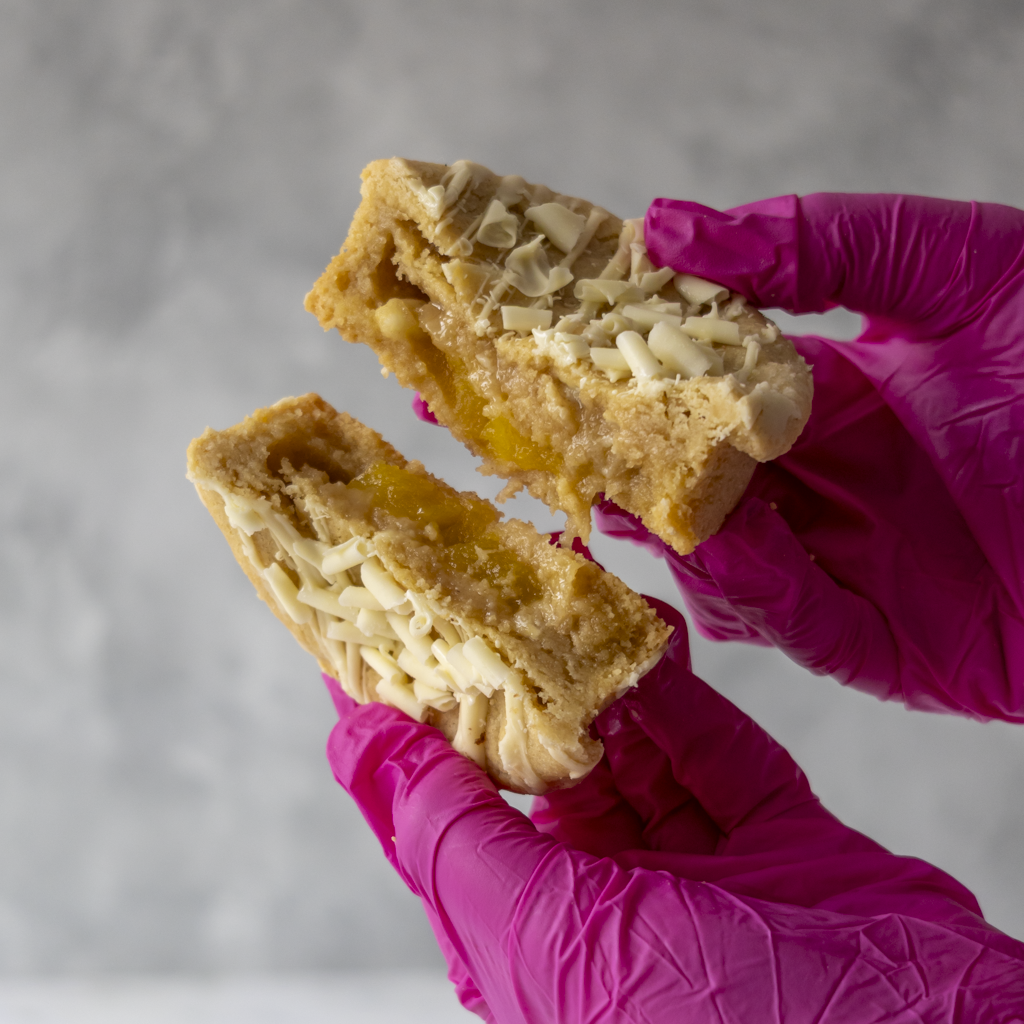 DoughGirl Stuffed Lemon and White Chocolate Deluxe Cookie broken open with lemon curd filling